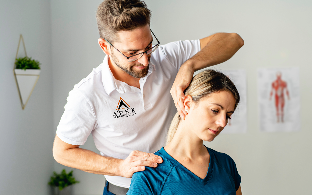A chiropractor from Apex Performance Chiropractic performing a neck adjustment on a female patient for the about us page.
